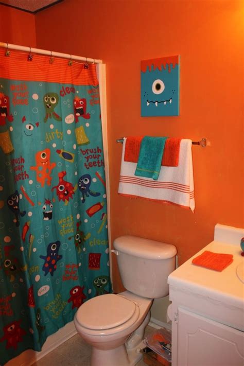 a bathroom with an orange wall and blue shower curtain, toilet and sink in it