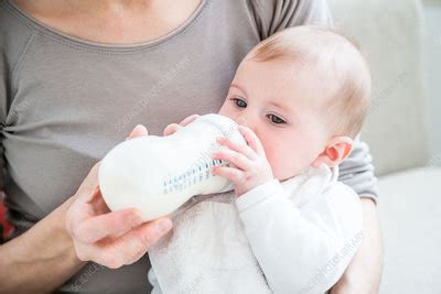 Baby girl drinking milk from a bottle - Stock Image - C035/3687 - Science Photo Library