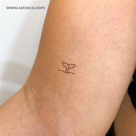 Minimalistic whale tail temporary tattoo located on the