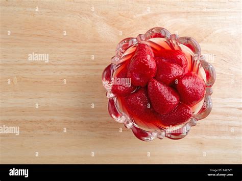 Top view of a glass bowl filled with canned strawberries in juice upon a wood table top Stock ...