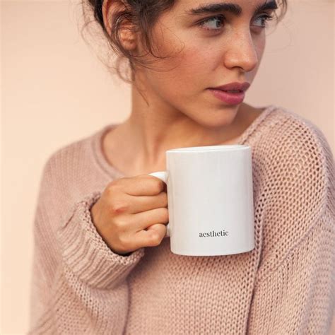 a woman is holding a coffee mug in her hands
