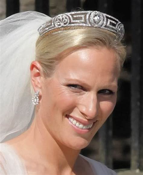 a woman wearing a tiara and smiling at the camera with a veil on her head