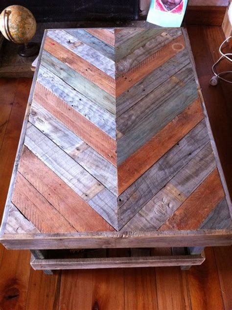 a coffee table made out of pallet wood with an arrow shaped top on it