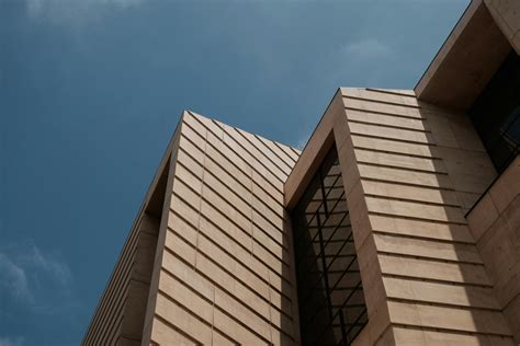Edificio De Hormigón Marrón Bajo Un Cielo Azul · Fotos de stock gratuitas