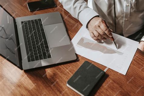 Premium Photo | Businessman with a laptop writing on a paper