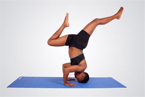Fitness woman doing head stand legs spread apart