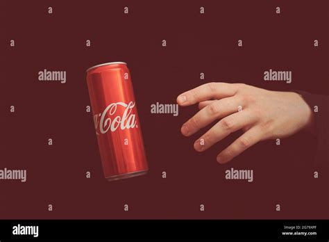 KALININGRAD, RUSSIA - MARCH 13, 2021 - Hand reaches to Coca Cola can ...