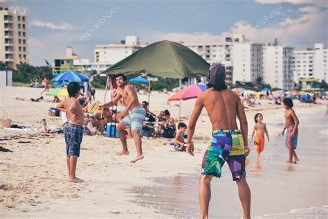 MIAMI BEACH, FL - CIRCA 2011: people rest on the beach by the blue ocean in Miami Beach, Florida ...