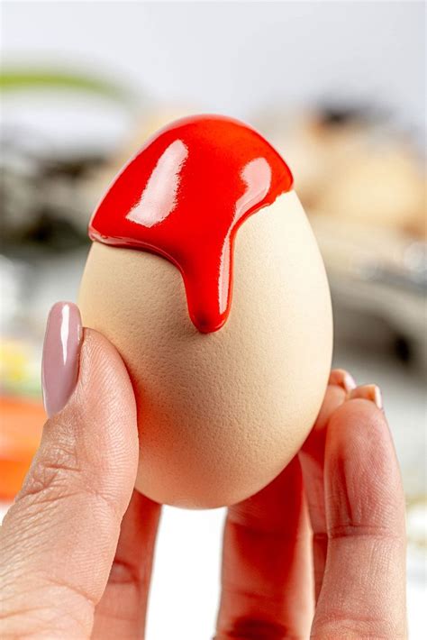 Close-up of red paint flowing down a chicken egg in a female hand - Creative Commons Bilder