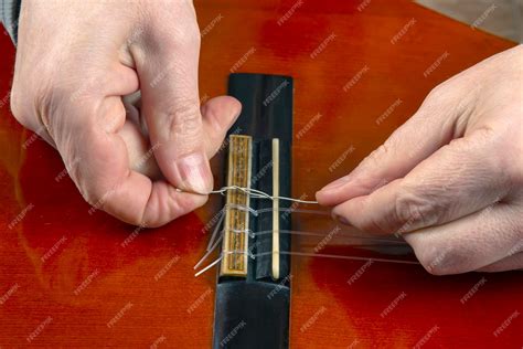 Premium Photo | Replacing and tuning nylon strings on a six-string classical guitar. instruction ...