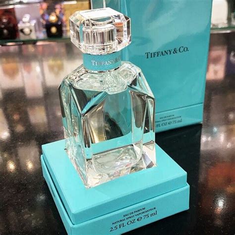 a bottle of tiffany & co perfume sitting on top of a table next to a box