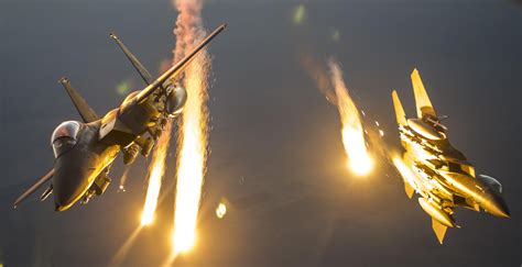 Two F-15 Eagles drop flares after receiving fuel from a KC-135 ...