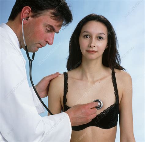 GP listening to woman's heart with stethoscope - Stock Image - M920 ...