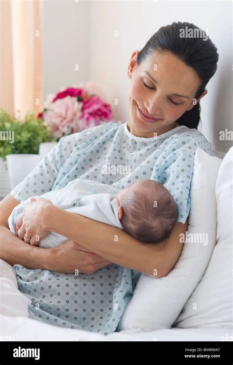 Mother holding newborn baby in hospital bed Stock Photo - Alamy