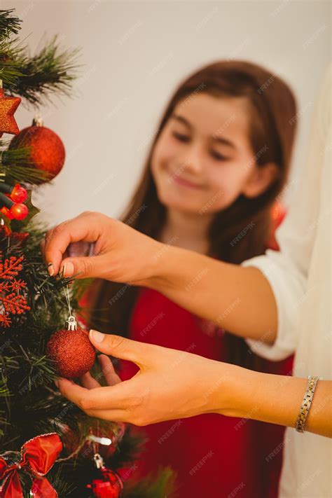 Premium Photo | Woman hanging christmas decorations on tree