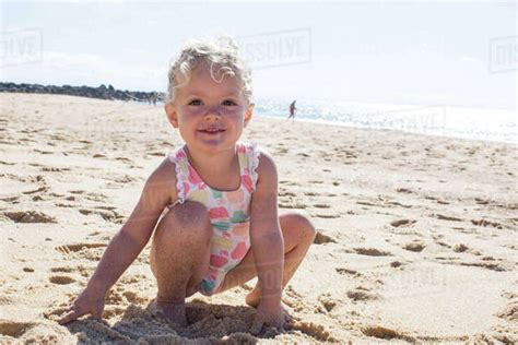 Girl making angel in sand on beach, high angle view - Stock Photo ...