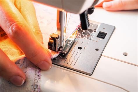 Premium Photo | Female hands work on the sewing machine closeup sewing ...