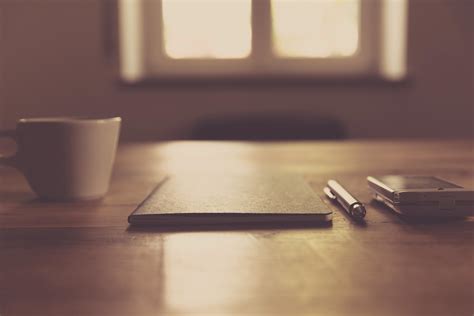 Black Closed Notebook Beside Click Pen and White Cup · Free Stock Photo