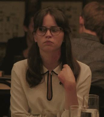 a woman sitting at a table with glasses on her head and looking to the side