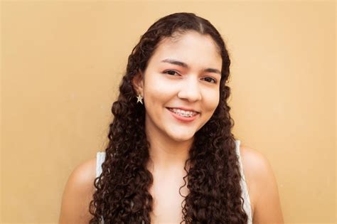 Premium Photo | Portrait of latin american young woman smiling with brackets over wall color yellow