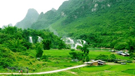 a lush green valley filled with lots of trees and water fall in the ...