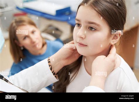 Female doctor examining child lymph nodes in clinic Stock Photo - Alamy