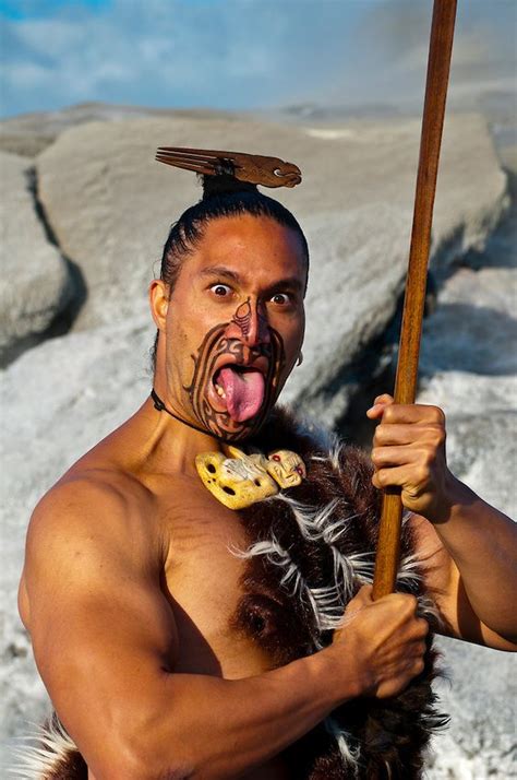 A Maori warrior with a ta moko (facial tattoo) performs a war haka ...