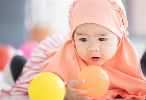 Premium Photo | Muslim baby plays with colorful toys in the living room