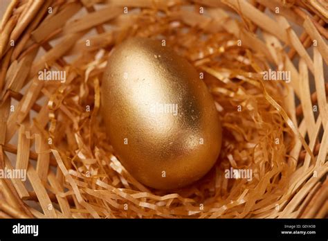 golden egg in a basket Stock Photo - Alamy