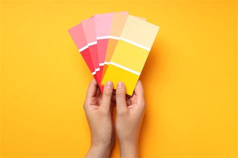 Premium Photo | Female hand holding color palettes on yellow background