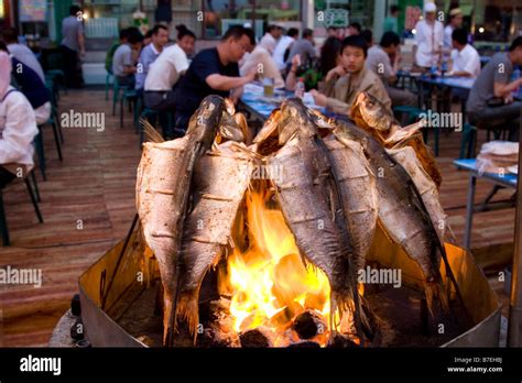 Grilling fish at the night market in Urumqi in Xinjiang in China Stock Photo - Alamy