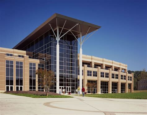 a large building with many windows and people walking around the outside area in front of it