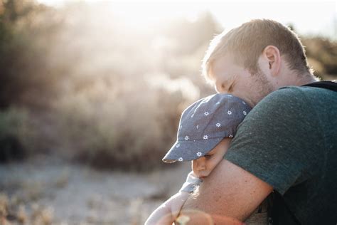 Man Hugging the Baby in Blue Floral Fitted Cap during Daytime · Free Stock Photo