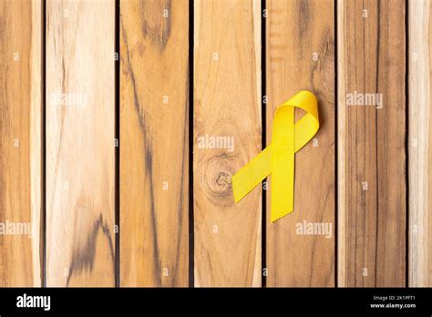 Yellow Ribbon on wooden table background for supporting people living and illness. September ...