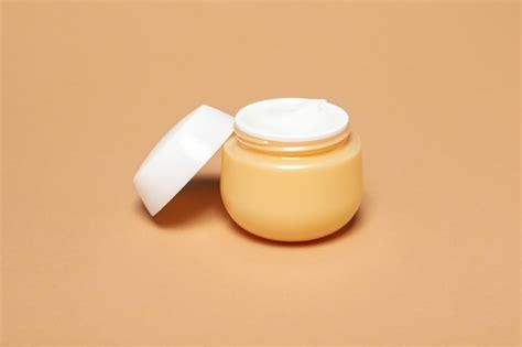 Premium Photo | Jar with cream on beige background close up