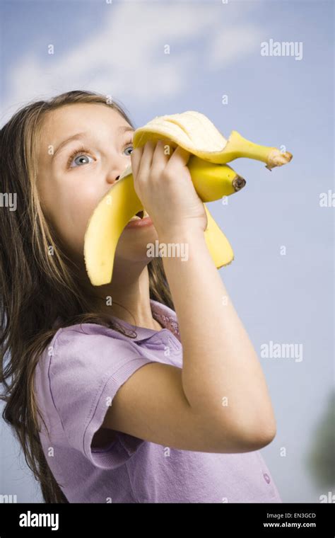 Young girl eating banana Stock Photo - Alamy