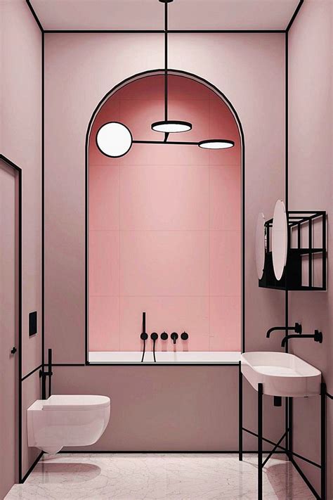 a white bathroom with pink walls and black fixtures on the ceiling, along with two sinks and a ...
