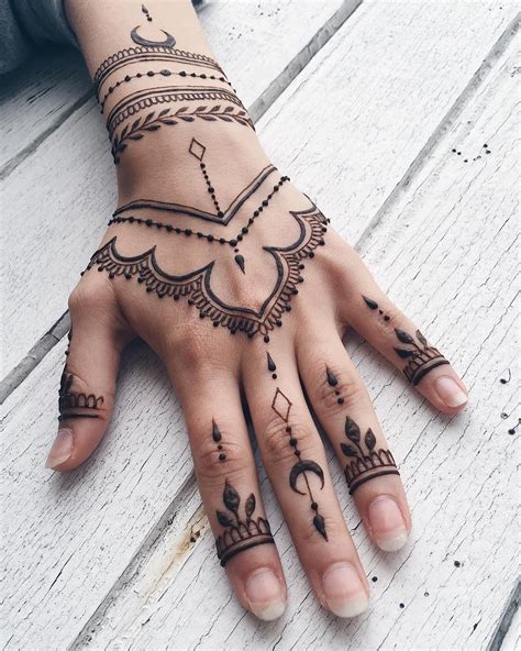 a woman's hand with henna tattoos on it