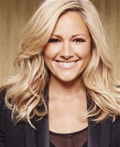 a woman with blonde hair smiling and wearing a blazer over a black dress shirt