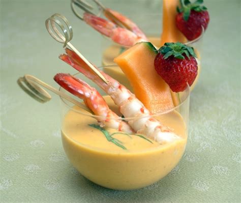 there are some fruit sticks sticking out of a small glass cup filled with cheese and strawberries