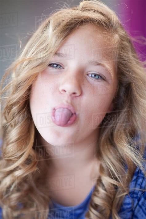 Girl sticking her tongue out - Stock Photo - Dissolve