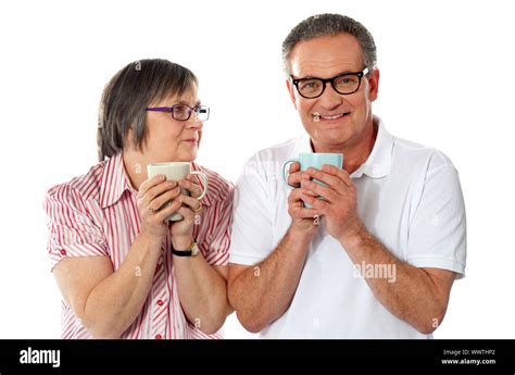 Romantic senior couple holding coffee mugs isolated over white Stock Photo - Alamy