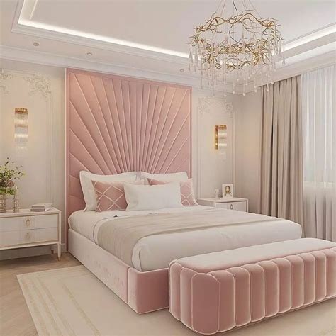 a bedroom with a large bed, chandelier and pink velvet upholstered ...