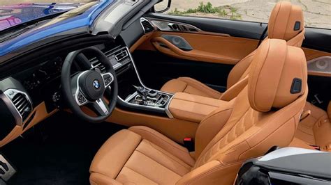 the interior of a car with tan leather and black trims, including steering wheel