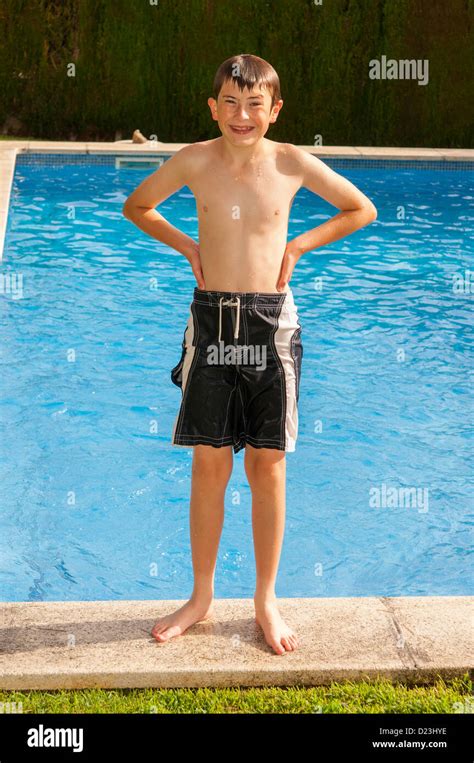 A 12 year old boy standing by a swimming pool Stock Photo: 52940370 - Alamy