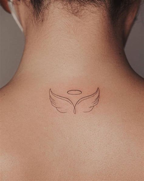 Minimalist angel wings tattoo on the upper back.