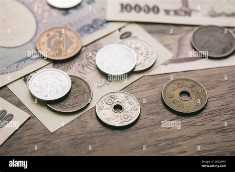 Closeup of Japanese yen money bills and coins on wood table background ...