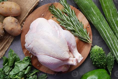 raw whole chicken and green vegetables on table, top view 3024170 Stock ...