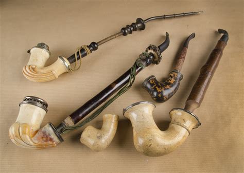 A collection of six meerschaum pipes, five with carved faces, including one young woman, three of