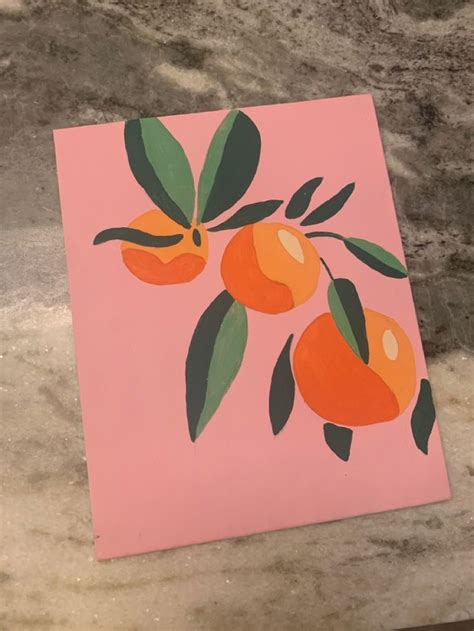 an orange painting on a pink background with green leaves and two oranges hanging from the tree